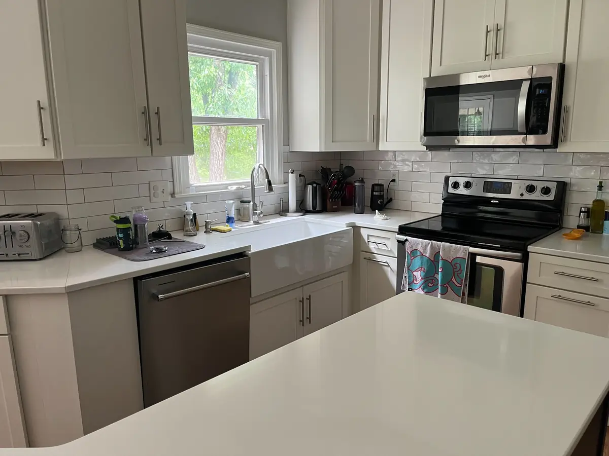 Kitchen with farmhouse sink and white cabinets — before