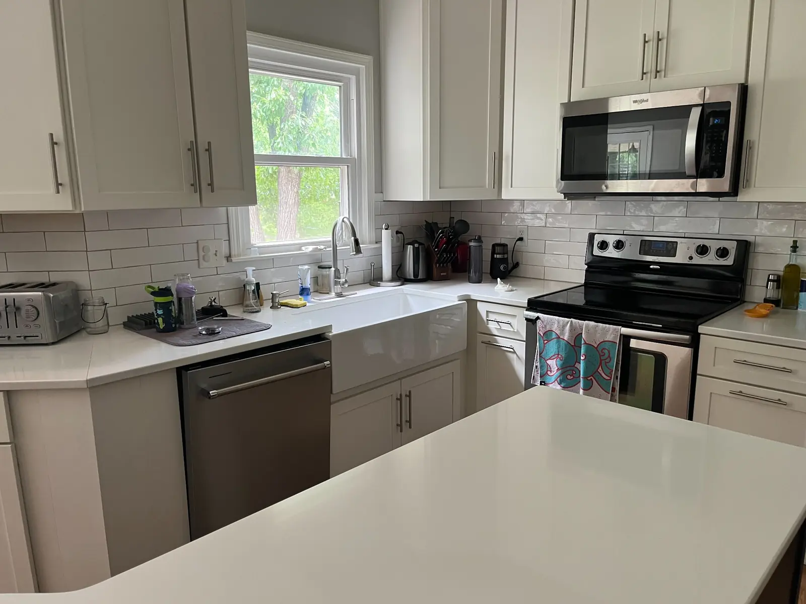 Kitchen with farmhouse sink and subway-tile backsplash — before